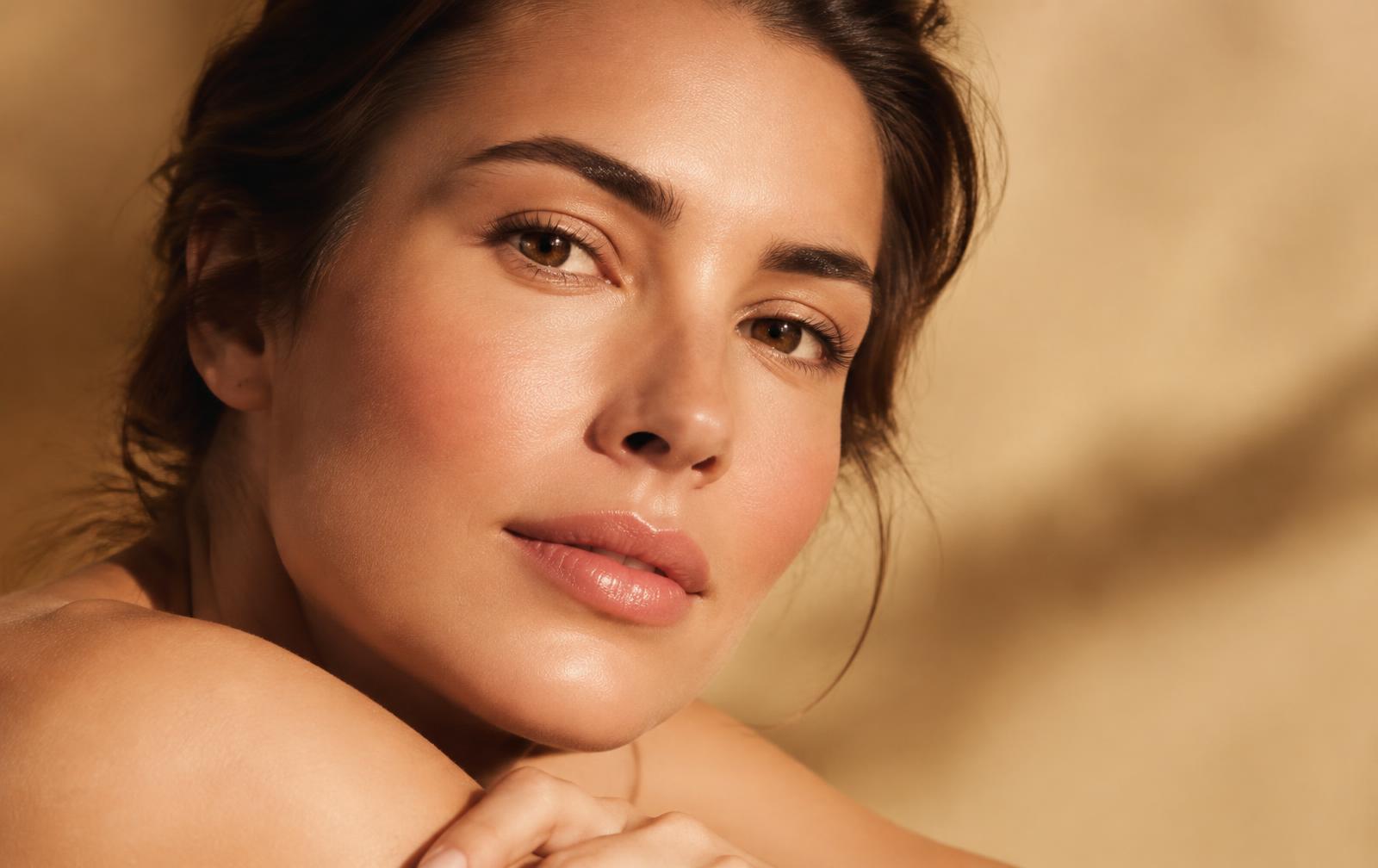 Woman with even, luminous skin in warm light